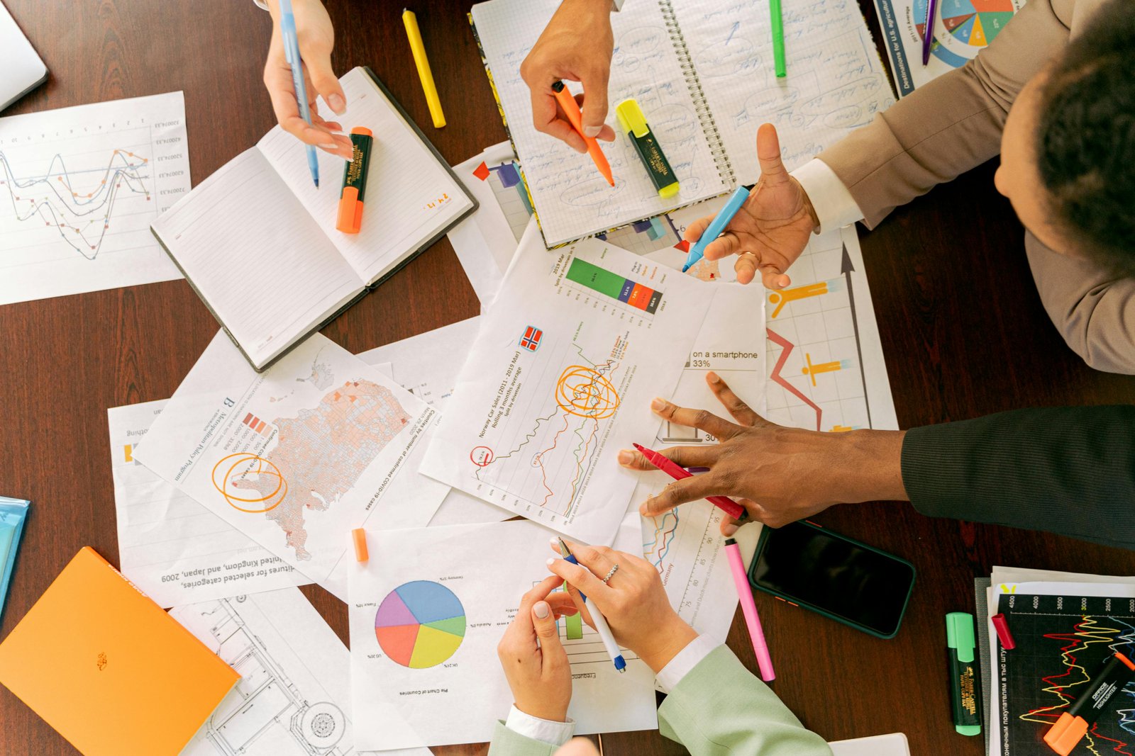 Business team discussing SEO tools with graphs and documents on a table.