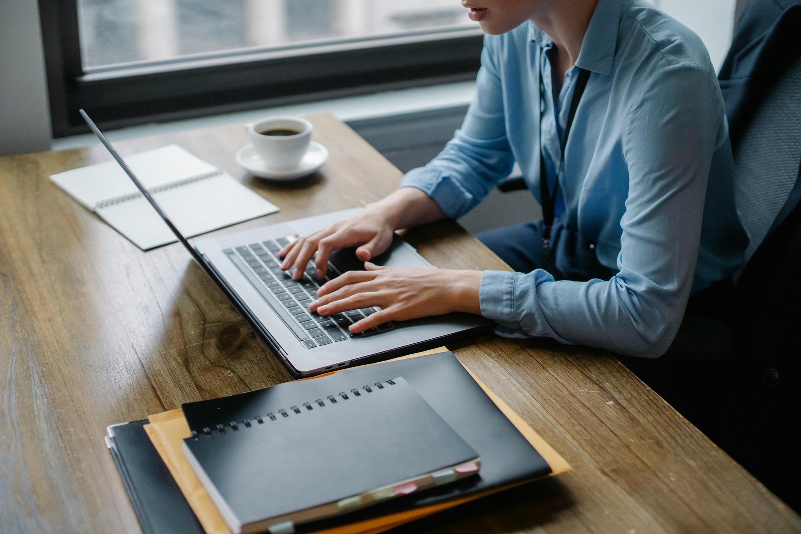 Woman on a laptop with notes and coffee on her work desk - Most Affordable Keyword Research Tool for 2023