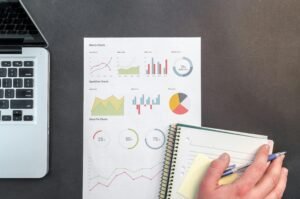 Analytics dashboard with hand on a notebook
